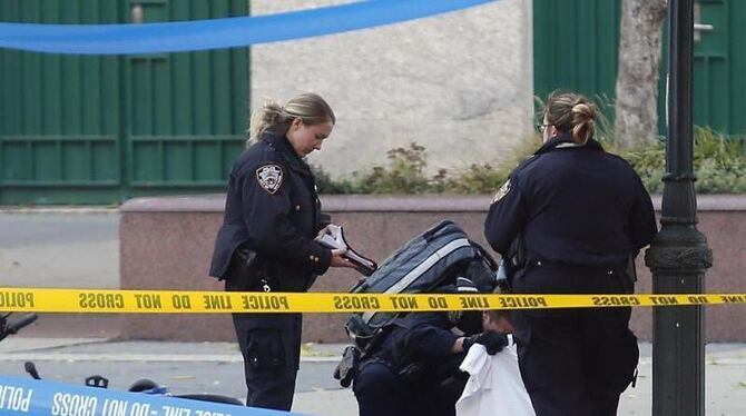 Polizisten untersuchen auf dem Fahrradweg einen abgedeckten Körper. Foto: Bebeto Matthews