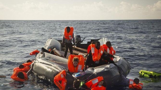 Flüchlinge treiben im Mittelmeer, bevor sie von Teams von SOS Mediterranée und Ärzte ohne Grenzen auf das Rettungsschiff "Aqu
