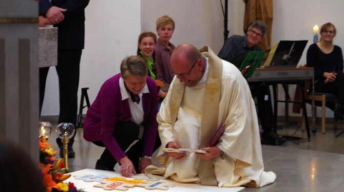 Der neue katholische Pfarrer Ambros Tungl legt zusammen mit Bärbel Kannwischer ein Puzzle in der Mössinger Marienkirche. FOTO: J