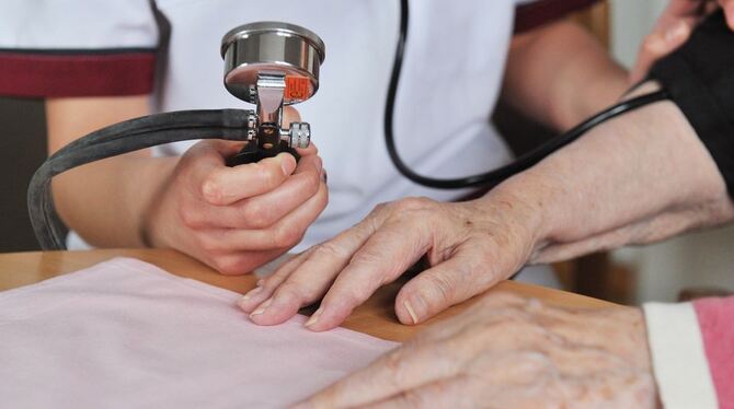 Eine Krankenpflegeschülerin mißt einer Seniorin den Blutdruck. Doch viele Pflegestellen bleiben unbesetzt.
