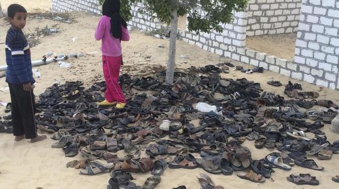 Kinder neben Schuhen von Opfern des verheerenden Terroranschlags auf die Moschee. Foto: AP