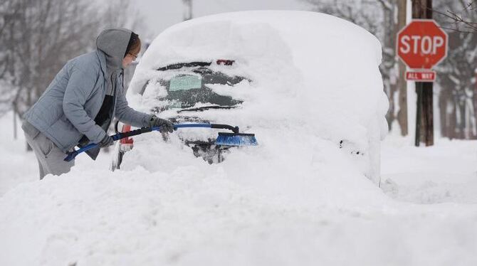 Ein Amerikaner versucht im US-Bundesstaat Pennsylvania sein Auto vom Schnee zu befreien. Foto: Jack Hanrahan/Erie Times-News