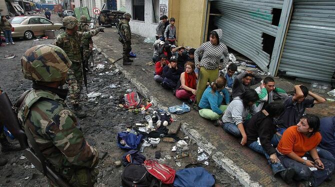 Soldaten nehmen in Chile Plünderer fest.
