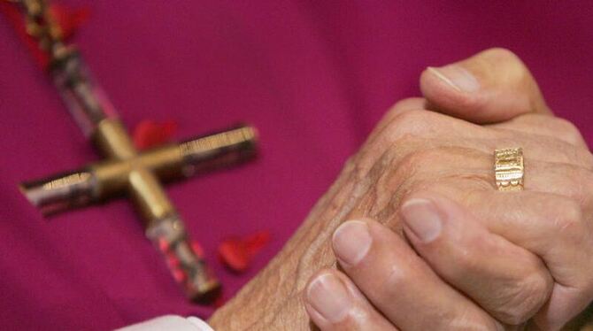 Mit gefalteten Händen nimmt ein katholischer Bischof an einem Gottesdienst teil. (Symbolbild)