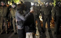 Zwei junge Demonstranten küssen sich vor einer Polizeikette am Boxhagener Platz in Berlin. 