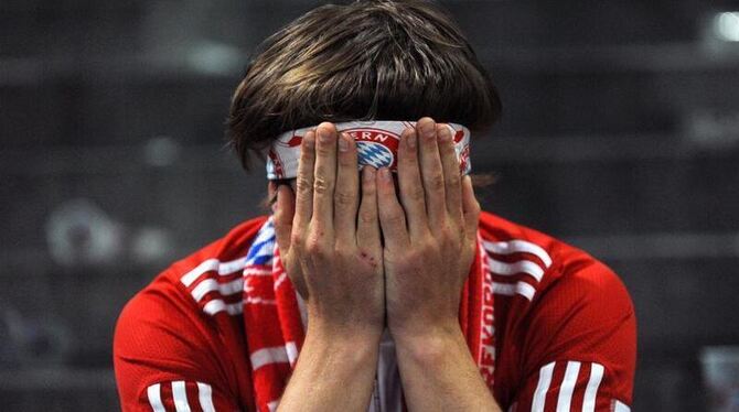 Das schmerzt: Ein Bayern-Fan vergräbt in der Allianz Arena in München sein Gesicht in seinen Händen.