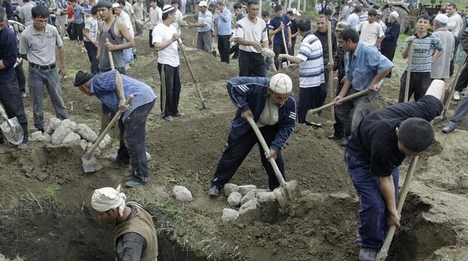 Usbekische Männer heben notdürftig Gräber aus. Dem Konflikt zwischen Kirgisen und Usbeken sind bereits rund 120 Menschen zum