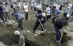 Usbekische Männer heben notdürftig Gräber aus. Dem Konflikt zwischen Kirgisen und Usbeken sind bereits rund 120 Menschen zum 