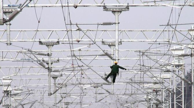 Ein Arbeiter montiert Elektroleitungen an der Baustelle einer Eisenbahn im Südosten Chinas.