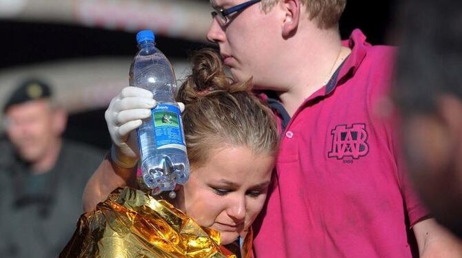 Menschen trösten sich in Duisburg nach der Massenpanik bei der Loveparade. 