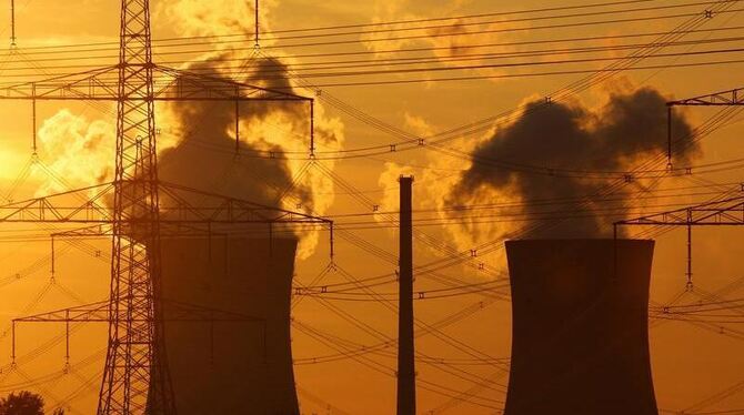 Die Kühltürme eines Atomkraftwerks im Licht der untergehenden Sonne.
