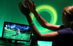 Eine Frau spielt mit der neuen Xbox 360 von Microsoft auf der Gamescom in Köln.