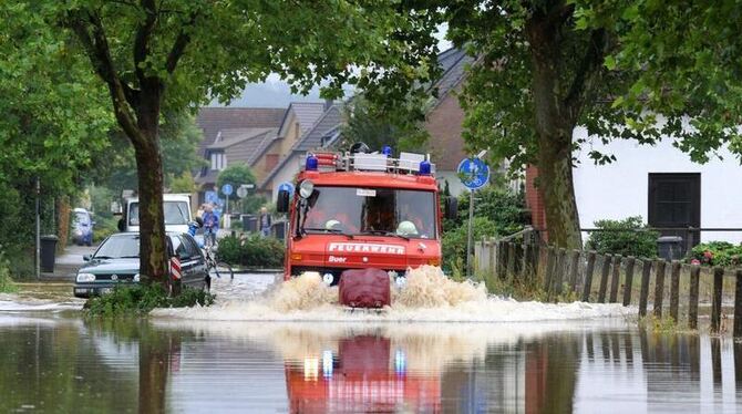 Ein Feuerwehrfahrzeug fährt im niedersächsischen in Westerhausen durch eine überschwemmte Straße.