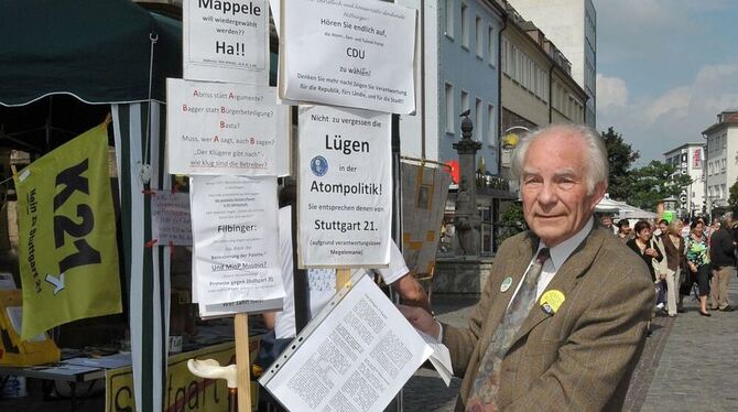 Wilfried Hüfler mit seiner Protesthilfe vor der Reutlinger Nikolaikirche.  FOTO: NIETHAMMER