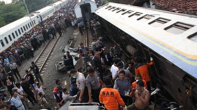 Retter suchen in den Trümmern des in Zentral-Java verunglückten Zugs nach Überlebenden. 