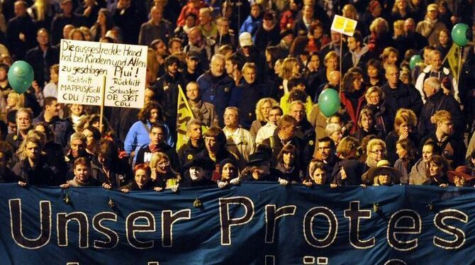 Demonstranten tragen während einer Großdemonstration in Stuttgart ein Transparent mit der Aufschrift "Unser Protest wird schä