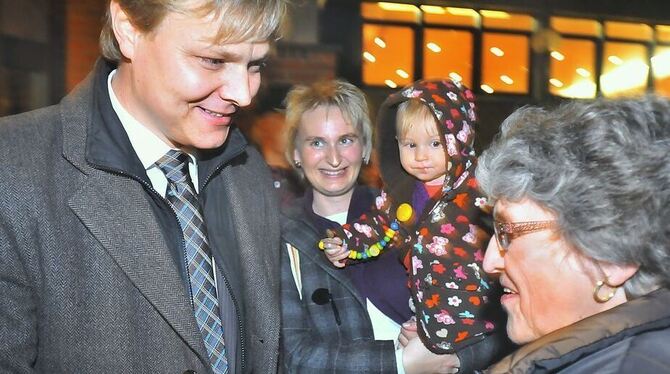 Peter Nußbaum nimmt am Wahlabend freudig die ersten Gratulationen entgegen, während seine Frau Anja und Töchterchen Sophie sicht