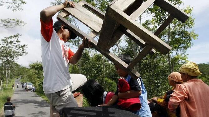 Dorfbewohner packen ihre Habseligkeiten und flüchten vor dem erneuten Ausbruch des Merapi.