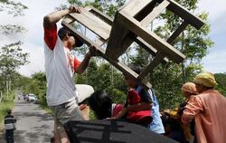 Dorfbewohner packen ihre Habseligkeiten und flüchten vor dem erneuten Ausbruch des Merapi.