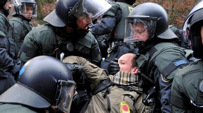 Polizeikräfte schleppen einen Demonstranten weg.
