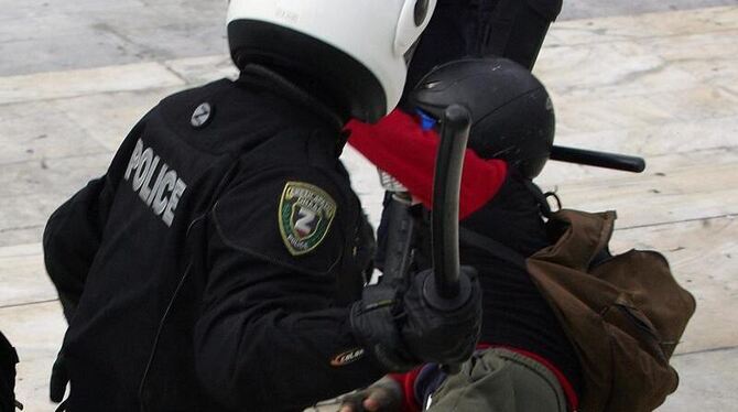 Knüppel frei: Ein griechischer Polizist in Athen droht einem am Boden liegenden Demonstranten mit einem Schlagstock (Archivbi