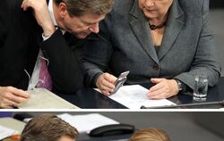 Meins ist flacher: Kanzlerin Angela Merkel und Außenminister Guido Westerwelle vergleichen während der Debatte im Bundestag am 2