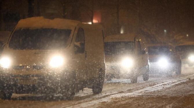 Autos fahren bei dichtem Schneefall durch Berlin.