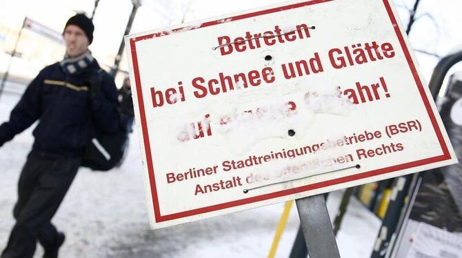 Ein Warnschild mit der Aufschrift »Betreten bei Schnee und Glätte auf eigene Gefahr« in Berlin.