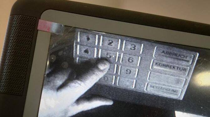 Mit einer Mini-Kamera wird die Eingabe einer Geheimnummer im Tastenfeld eines Bankautomaten beobachtet.