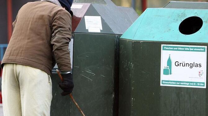 Ein Mann sucht in einem Altglas-Container nach Pfandflaschen (Archivfoto). Ein Mann sucht in einem Altglas-Container nach Pfandflaschen (Archivfoto).