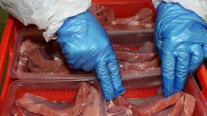 Ein Mitarbeiter einer Fleischfirma verpackt Schnitzel (Symbolbild).