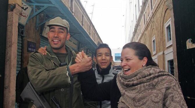 Eine tunesische Frau posiert zusammen mit einem Soldaten für den Fotografen.