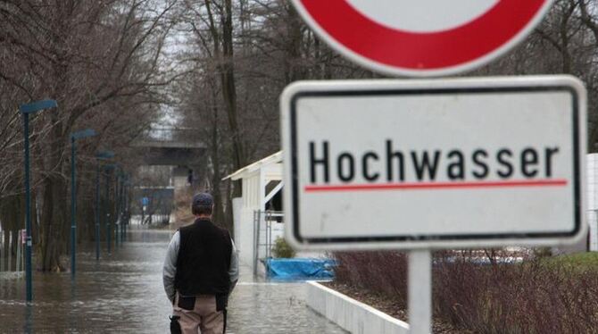 Hochwasser-Warnschild auf einem Fußweg bei Magdeburg.