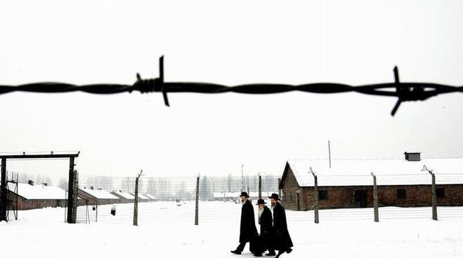 Eine Gruppe orthodoxer Juden geht über das Gelände des früheren Konzentrationslagers Auschwitz. Seit 1996 wird in Deutschland