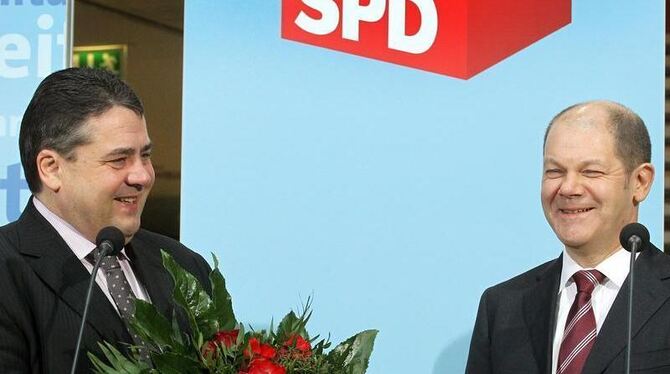 Mit einem Blumenstrauß wird der Wahlsieger der Bürgerschaftswahl in Hamburg, Olaf Scholz, in der Parteizentrale der SPD in Be