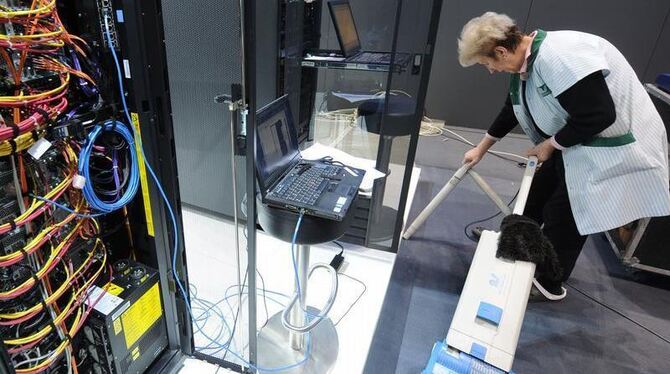 Vorbereitung: Eine Reinigungskraft arbeitet auf dem IBM CeBIT-Stand neben einem rund 80 Terrabyte großen Speicherschrank. 