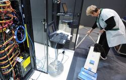 Vorbereitung: Eine Reinigungskraft arbeitet auf dem IBM CeBIT-Stand neben einem rund 80 Terrabyte großen Speicherschrank. 