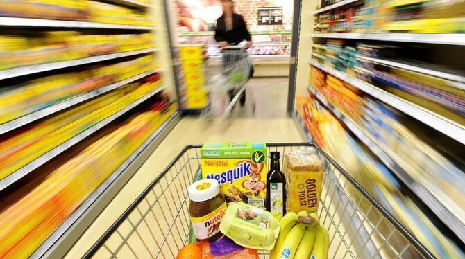 Ein Einkaufswagen mit verschiedenen Lebensmitteln wird durch einen Supermarkt geschoben. (Illustration)