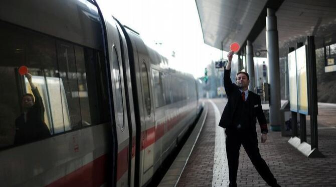 Ein Zugbegleiter gibt im ICE-Bahnhof Wilhelmshöhe in Kassel mit der roten Kelle das Signal für die Abfahrt.