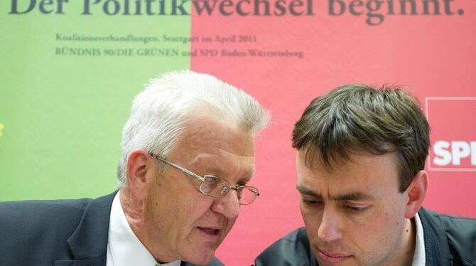 Der baden-württembergische Ministerpräsident Winfried Kretschmann (l, Grüne) und SPD-Landeschef Nils Schmid unterhalten sich Stu