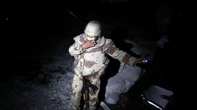 Ein lybischer Soldat in Gaddafis Anwesen in Tripolis: Am frühen Morgen zerstörten Nato-Angriffe ein Gebäude auf dem Anwesen.