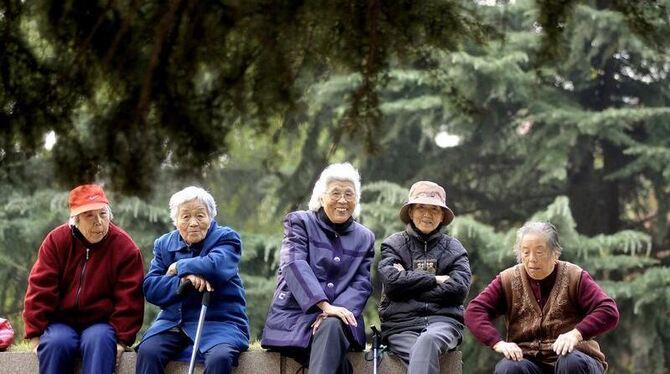 Seniorinnen sitzen in einem Park von Qingdao (Ostchina, Shandong-Provinz).