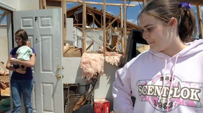 Einwohner von Pleasant Grove, Alabama stehen in einem vom Tornado zerstörten Haus.