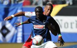 Freiburgs Doppeltorschütze Papiss Demba Cissé setzt sich spielend gegen Hamburgs Dennis Aogo (r) durch.