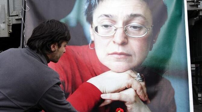 Ein Mann legt an einem Porträt von Anna Politkowskaja in Moskau eine Nelke nieder (Archivfoto).