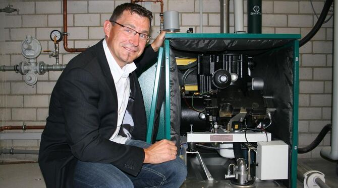 Der Technische Leiter der Stadtwerke Metzingen, Giancarlo Bragagnolo, vor einem kleinen Blockheizkraftwerk, das Wärme und Strom Der Technische Leiter der Stadtwerke Metzingen, Giancarlo Bragagnolo, vor einem kleinen Blockheizkraftwerk, das Wärme und Strom