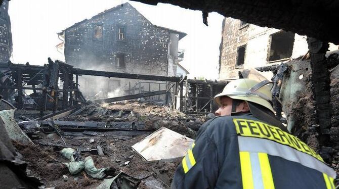 Ein Feuerwehrmann sucht nach den Großbrand in Delmenhorst nach Glutnestern.