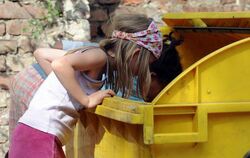 Zwei Kinder wühlen in Berlin-Kreuzberg in einer Mülltonne.