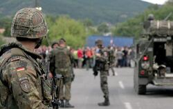 Ein deutscher Soldat steht an einer Straßenblockade im Kosovo. Die Bundeswehr schickt weitere Soldaten in das Land.