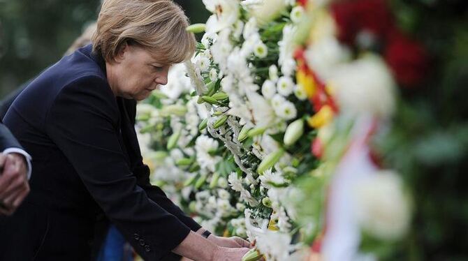 Bundeskanzlerin Angela Merkel legt während der Gedenkveranstaltung auf dem Gelände der Mauergedenkstätte an der Bernauer Stra
